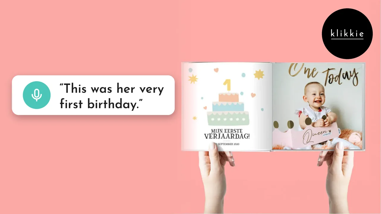 Hände halten ein aufgeschlagenes klikkie Fotobuch My First Year mit der Seite zum ersten Geburtstag, mit den Worten „This was her very first birthday.“